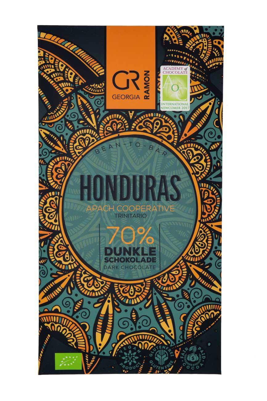Verpackung der "Honduras 70%" Schokolade von Georgia Ramon - dunkelblauer Hintergrund, darauf stilisiert eine große Schildkröte in türkis und orange mit Mandala-Muster, 