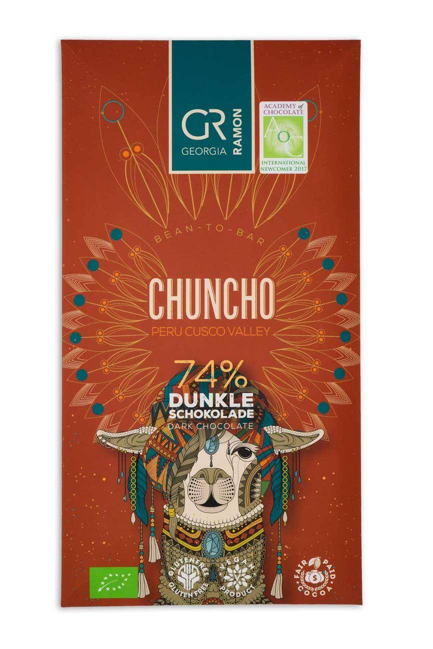 Verpackung der "Chuncho 74%" Schokolade von Georgia Ramon - rostroter Hintergrund mit blassem Feder-Mandala-Muster, im Vordergrund ein Lama mit bunten Perlen als Kopfschmuck