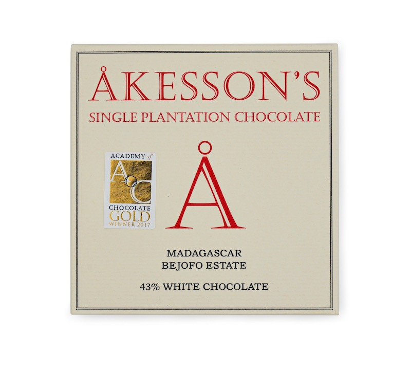 Verpackung der weißen Schokolade von Akesson’s in cremefarbener Pappe mit roter und schwarzer Aufschrift und goldenem Sticker der „Academy of Chocolate“-Auszeichnung.