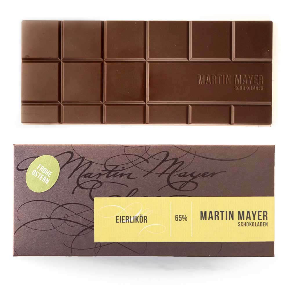 Verpackung und ausgepackte Tafel der Eierlikör_Schokolade von Martin Mayer. Die Verpackung ist dunkelbraun mit hellgelbem Etikett und grünem Sticker mit der Aufschrift "Frohe Ostern".