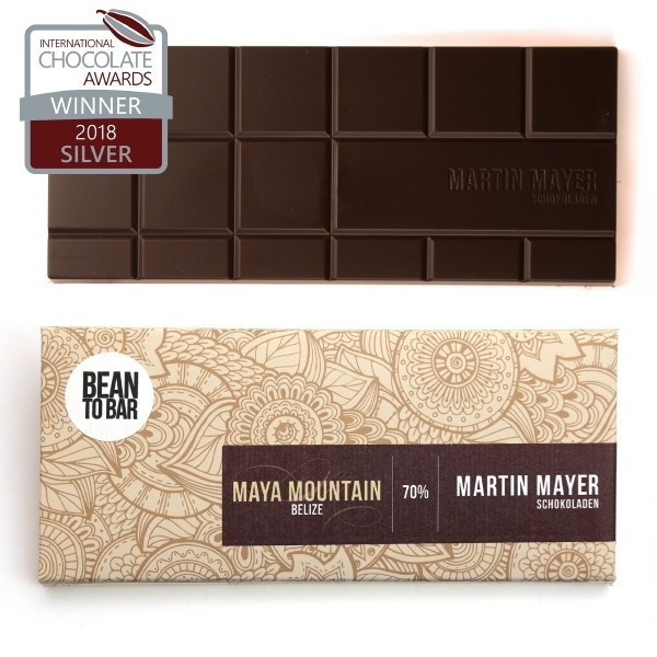 Martin Mayer Dunkle Schokolade Maya Mountain-Belize 70 Prozent - Verpackung aus beigem Papier mit floralem Mandala-Muster und dunkelbrauner Banderole.